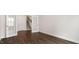 Open living room featuring dark hardwood floors, an open doorway, and staircase access at 79 Bronco Pace Dr, Clayton, NC 27520