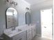 The bathroom has double sinks, modern fixtures, large mirrors, and a tile shower to create a fresh, updated space at 802 Shade Tree Rd, Benson, NC 27504