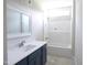 A well-lit bathroom features a new vanity with sink and faucet next to a shower/tub combo with tiled walls at 802 Shade Tree Rd, Benson, NC 27504