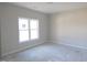 Clean and bright bedroom space featuring bare floors, light walls, a window for natural light, and electrical outlets at 802 Shade Tree Rd, Benson, NC 27504