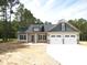 Charming new construction home features a two-car garage, a well-manicured lawn, and complementary siding and stonework at 802 Shade Tree Rd, Benson, NC 27504