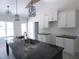 Kitchen featuring dark granite countertops, white cabinets, a large sink, and modern light fixtures at 802 Shade Tree Rd, Benson, NC 27504