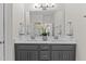 Bright bathroom with dual sinks, gray cabinets, and a large vanity mirror at 8304 Southmoor Hill Trl, Wake Forest, NC 27587