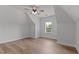 Upstairs bedroom features hardwood floors, a ceiling fan and large window at 8304 Southmoor Hill Trl, Wake Forest, NC 27587