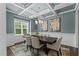 Elegant dining room features a coffered ceiling, modern chandelier, and a table with seating for six at 8304 Southmoor Hill Trl, Wake Forest, NC 27587