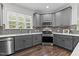 Charming kitchen features gray cabinets, stainless steel appliances, and beautiful countertops at 8304 Southmoor Hill Trl, Wake Forest, NC 27587
