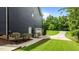 Side of house featuring a well-maintained lawn, leading to the garage and a private outdoor area at 8304 Southmoor Hill Trl, Wake Forest, NC 27587