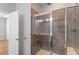 Tiled shower with glass enclosure and modern fixtures in this primary bathroom at 9327 Falkwood Rd, Raleigh, NC 27617