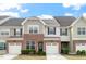 Charming townhome with brick facade, one-car garage, and manicured front yard at 9327 Falkwood Rd, Raleigh, NC 27617