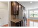 Kitchen featuring stainless steel appliances, dark cabinets, and granite countertops at 9327 Falkwood Rd, Raleigh, NC 27617