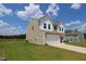 Side view of a two-story home featuring neutral siding, a white garage, and a well-maintained lawn at 935 Bombardier Ln, Spring Hope, NC 27882
