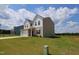 Angle view of a two-story home featuring neutral siding, a white garage, and a well-maintained lawn at 935 Bombardier Ln, Spring Hope, NC 27882