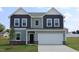 Two-story home featuring a two-car garage, modern siding, and a well-manicured lawn at 956 Bombardier Ln, Spring Hope, NC 27882