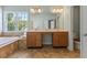 Bathroom featuring a vanity with double sinks, a tub, and a window at 9603 Clubvalley Way, Raleigh, NC 27617