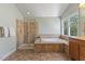 Bright bathroom featuring a vanity, tub with tile surround, and glass shower at 9603 Clubvalley Way, Raleigh, NC 27617