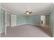 Bright bedroom with neutral carpet, ceiling fan, and two doorways at 9603 Clubvalley Way, Raleigh, NC 27617