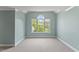 Cozy bedroom featuring a neutral carpet and a large window for natural light at 9603 Clubvalley Way, Raleigh, NC 27617
