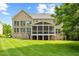 Rear exterior view shows a brick home with a sunroom addition overlooking the large backyard at 9603 Clubvalley Way, Raleigh, NC 27617