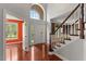 Bright foyer with hardwood floors, a staircase, and a view of a large arched window above the front door at 9603 Clubvalley Way, Raleigh, NC 27617