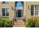 Elegant brick home featuring a front door with sidelights and transom window, framed by lush landscaping at 9603 Clubvalley Way, Raleigh, NC 27617