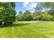 Lush front yard featuring a green lawn, trees, and landscaping at 9603 Clubvalley Way, Raleigh, NC 27617