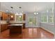 A kitchen and breakfast nook with hardwood floors, cherry cabinets, an island, and access to the outdoor deck at 9603 Clubvalley Way, Raleigh, NC 27617