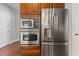 A close up of stainless steel appliances built into cherry cabinets, located in the kitchen at 9603 Clubvalley Way, Raleigh, NC 27617