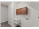 Practical laundry room featuring upper cabinets, a utility sink, and a white door, ideal for everyday tasks at 9603 Clubvalley Way, Raleigh, NC 27617