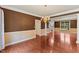 A spacious living room features hardwood floors, a chandelier, and large windows for ample natural light at 9603 Clubvalley Way, Raleigh, NC 27617