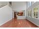 Open-concept living room with hardwood floors, large windows, and a view into the kitchen at 9603 Clubvalley Way, Raleigh, NC 27617