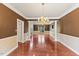 A bright living room features hardwood floors, a chandelier, and is columned off from another room at 9603 Clubvalley Way, Raleigh, NC 27617