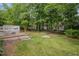 Lush backyard features a wooden deck and a well-manicured lawn surrounded by mature trees at 100 Wentbridge Rd, Cary, NC 27519