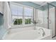 Relaxing bathroom boasts a soaking tub, large window, and glass-enclosed shower with tiled walls at 100 Wentbridge Rd, Cary, NC 27519