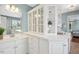 Bright bathroom featuring white cabinetry, glass shelving and plentiful counter space and view to bedroom at 100 Wentbridge Rd, Cary, NC 27519