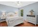 Tranquil bedroom features light blue walls, a plush bed, and complementing hardwood floors at 100 Wentbridge Rd, Cary, NC 27519