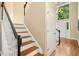 Hallway with wooden stairs and black railing, leading towards the front door at 100 Wentbridge Rd, Cary, NC 27519
