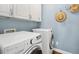 Efficient laundry room complete with white appliances, cabinetry and a convenient hat rack at 100 Wentbridge Rd, Cary, NC 27519