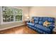 Inviting living room featuring a comfortable blue sofa and ample natural light from a large window at 100 Wentbridge Rd, Cary, NC 27519