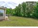 Expansive backyard featuring a manicured lawn and a backdrop of mature trees creating a private outdoor space at 1024 Holland Bend Dr Dr, Cary, NC 27519