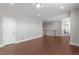 Large room with wood floors, a white door, and a staircase with a white railing at 1024 Holland Bend Dr Dr, Cary, NC 27519