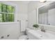 Well-lit bathroom with a window, white vanity, modern fixtures and tile flooring at 103 Oxford Cir, Knightdale, NC 27545