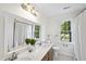 Bathroom boasts double sinks, large mirror, garden window, and shower with white curtain at 103 Oxford Cir, Knightdale, NC 27545