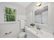 A well-lit bathroom showcases a white vanity, toilet, mirror and a window with outdoor views at 103 Oxford Cir, Knightdale, NC 27545