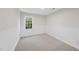Bright bedroom with carpet flooring, chair railing on walls and a window providing natural light and green outdoor views at 103 Oxford Cir, Knightdale, NC 27545