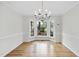 Bright dining room with hardwood floors, chandelier, and bay windows overlooking yard at 103 Oxford Cir, Knightdale, NC 27545