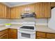 Traditional kitchen featuring wooden cabinets, a white electric stove, and ample counter space at 103 Oxford Cir, Knightdale, NC 27545