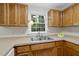 Kitchen showcases wood cabinets, stainless sink with window view, and a white appliance at 103 Oxford Cir, Knightdale, NC 27545