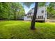 A spacious backyard with lush green grass, mature trees, wood fence and a deck at 104 S Crabtree Knl, Chapel Hill, NC 27514