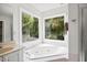 Bathroom with garden tub, tile floor and wall, with window to see outside at 104 S Crabtree Knl, Chapel Hill, NC 27514