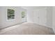 Bright bedroom with neutral carpet and double door closet, illuminated by two large windows at 104 S Crabtree Knl, Chapel Hill, NC 27514